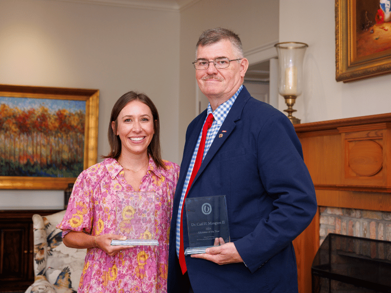 Early Career Award winner Johnna Riddick and Alumnus of the Year Dr. Carl Mangum hold their honors after the annual School of Nursing Alumni Awards Lunchoen.