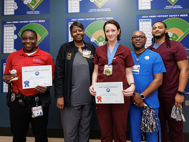 Carolyn Trudeau, center, holds a 2024 People’s Choice Award for Best Internal Customer Service during a ceremony in March. The award was presented to the adult supervisor staff. At right are are fellow adult house supervisors Calvin Ramsey and Jason Hayes, transfer coordinator Vera Smith, center-left, and police officer Shanice Mays, left.