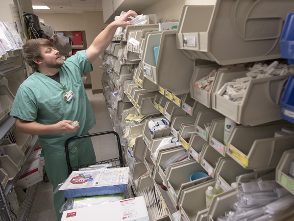 Matt Harris, a registered nurse in the Medical ICU, stocks bins with supplies needed for critical care.