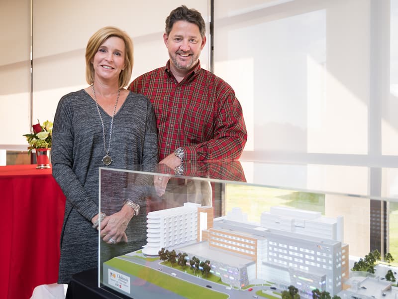 Priscilla and Dave O'Donnell show where their gift to the Campaign for Children's of Mississippi is going -- to help fund construction of a new children's tower, shown here in model form.
