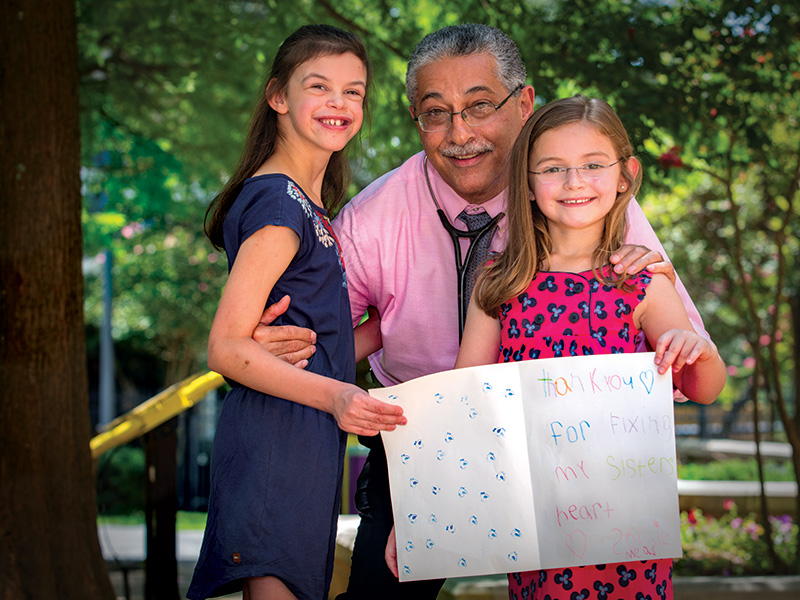 Dr. Makram Ebeid smiles with his patient, Sydney Mead of Madison, left, and her little sister, Sophie.