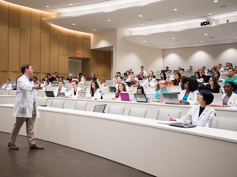 Dr. David Norris, associate professor of family medicine, teaches students in a medical education building amphitheatre.