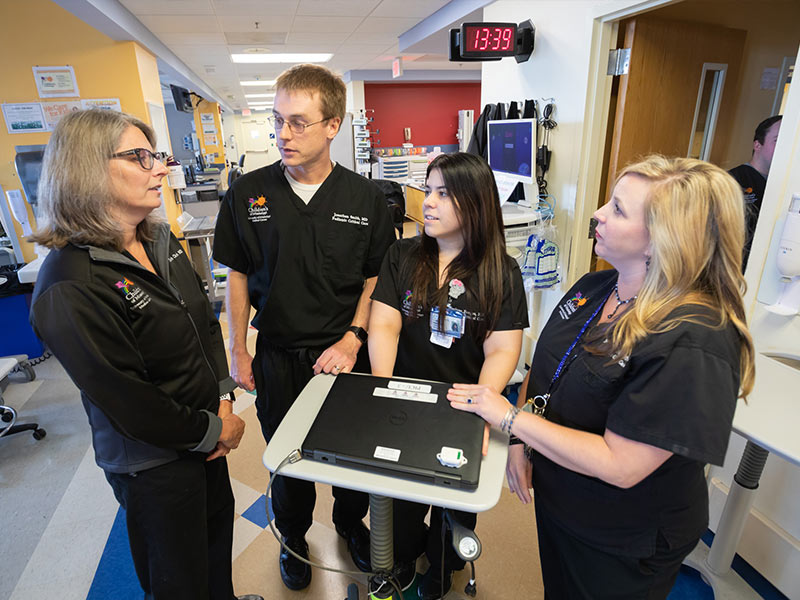 Dr. Elizabeth Christ, left, professor of pediatric critical care, talks with, from left, Dr. Jonathan Smith, Dr. Marivee Borges Rodriguez and Nikki Mayo, nurse practitioner.