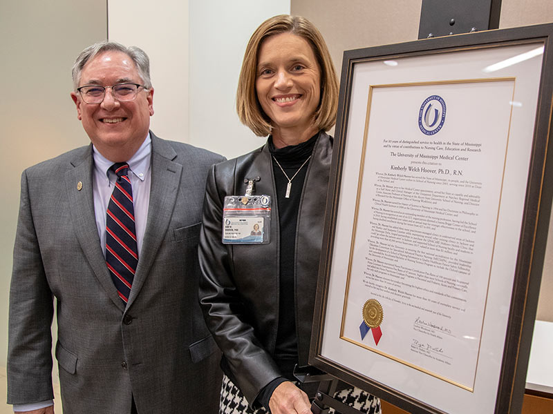 Dr. Kim Hoover receives a citation for her 30 years of distinguished service to health care in Mississippi from Dr. Ralph Didlake.