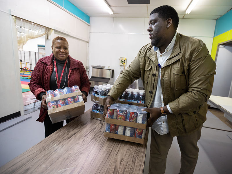 Beneta Burt, president and CEO of the Mississippi Urban League, and UMMC project administrator Darryl Jefferson unload canned goods for shelving at the EversCare Pantry.