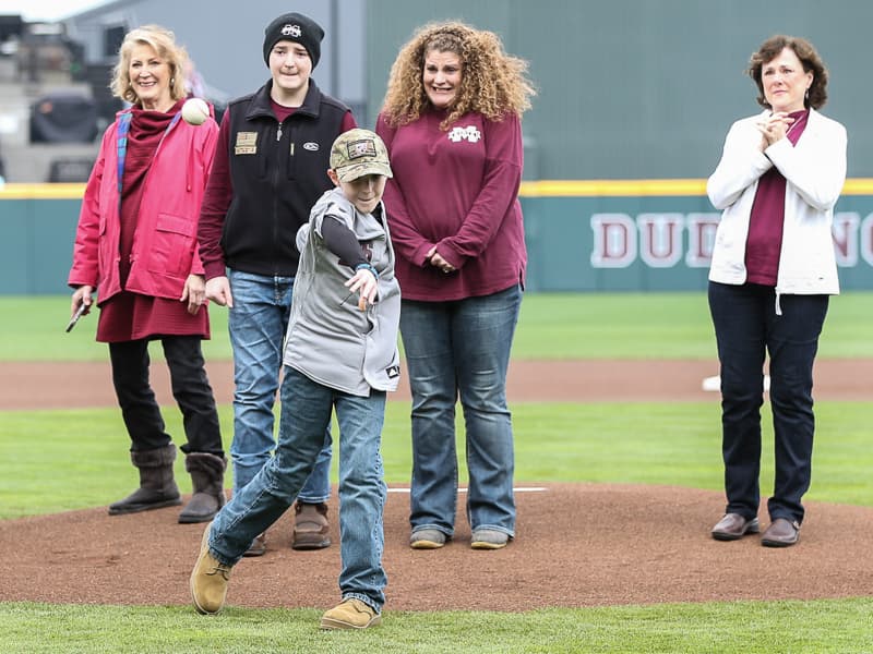 Corbin Connerley throws the first pitch Feb. 22 at a Mississippi State University home game. In the background from the right is Karen Connerley, mother of Jonathan Connerley; his brother Caleb; mom Gena; and Gena's aunt, Cindy Christian.