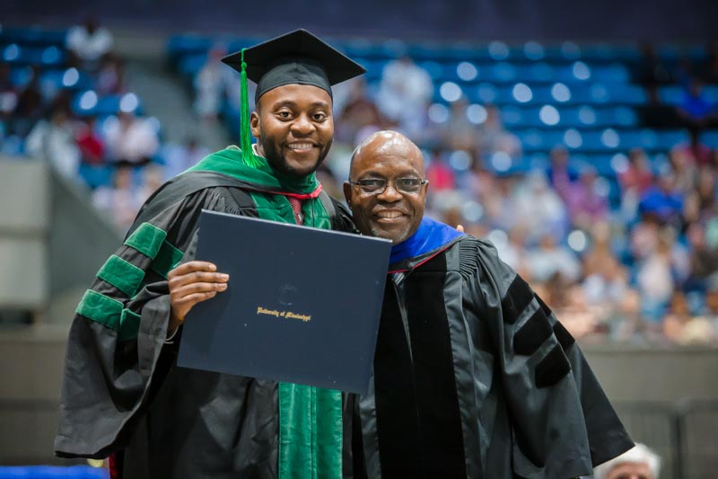School of Medicine graduate Dr. Sosa Adah received his hood from his father, Dr. Felix Adah, professor of physical therapy in the School of Health Related Professions.