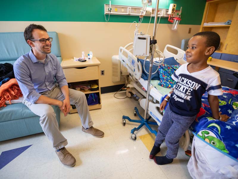 Alex Rueff, who served in the student chaplain position last year as a fourth-year medical student, shares a laugh with Princeton Donelson, Children's Hospital patient.