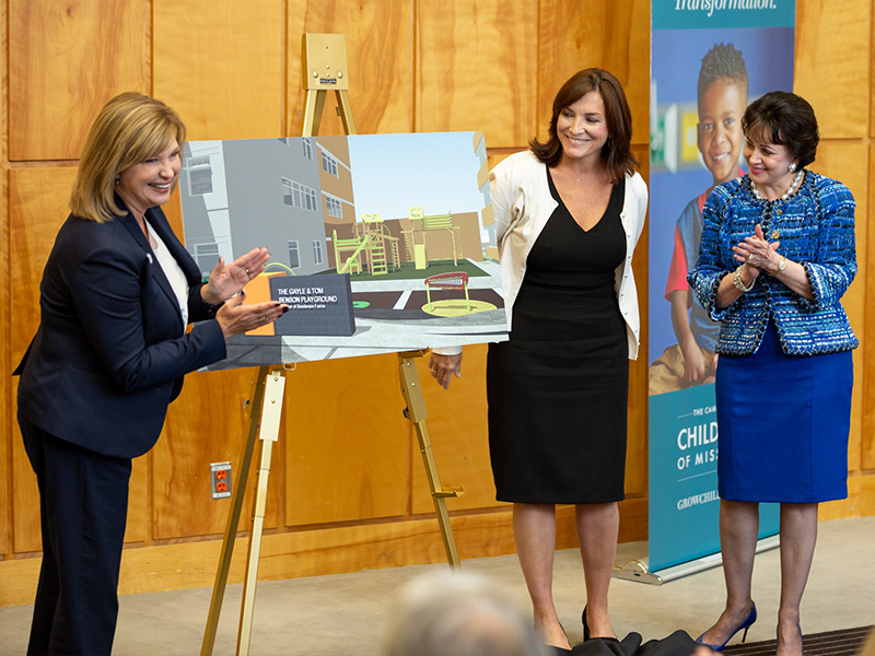 Dr. LouAnn Woodward, left, vice chancellor for health affairs and dean of the School of Medicine, applauds the $1 million gift from the Gayle & Tom Benson Charitable Foundation as Dr. Mary Taylor, Suzan B. Thames Chair, professor and chair of pediatrics, and Gayle Benson, right, owner of the New Orleans Saints and Pelicans, look on.