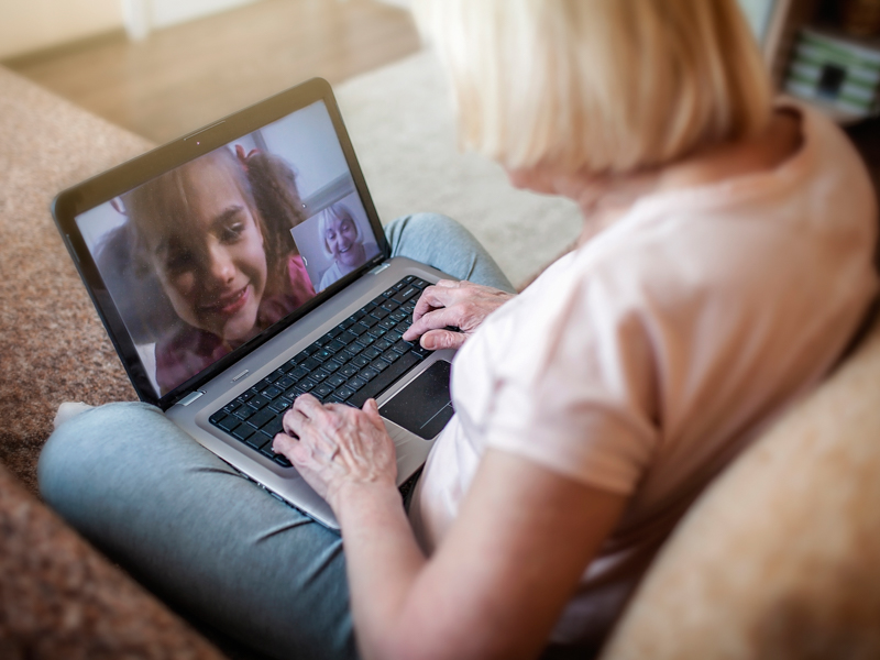 girl talking with her grandmother within video chat on laptop