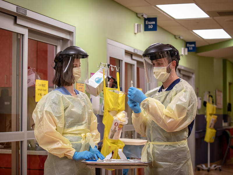 Anne Sinclair, a nurse in the pediatric emergency department, shows Oxford accelerated nursing student Logan Christian, right, how to apply proper PPE and how to perform a COVID-19 swab.