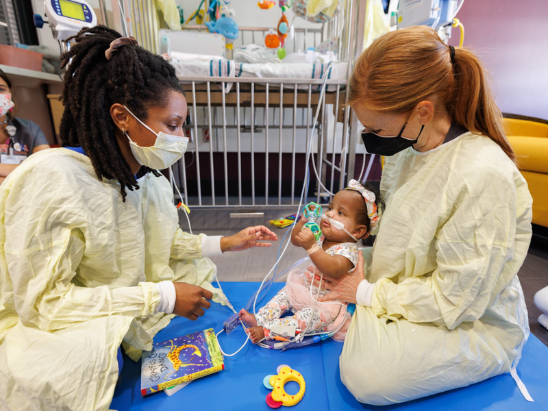 A’Nyla Rai Starks of West Point works hard on a number of skills during floor time in her individual NICU room in the new tower at the Children's Hospital with occupational therapist Iesha Smith, left, and physical therapist Elizabeth Woodcock. Joe Ellis/ UMMC Communications