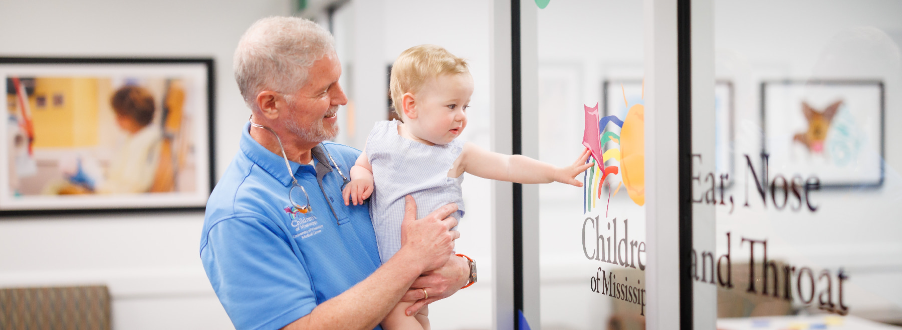 Children's of Mississippi provider holds children near door to ENT clinic