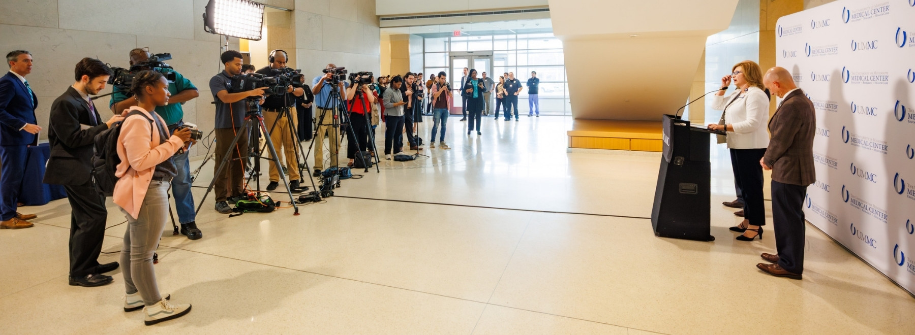Dr. LouAnn Woodward addresses a pool of reporters and accompanying videographers.