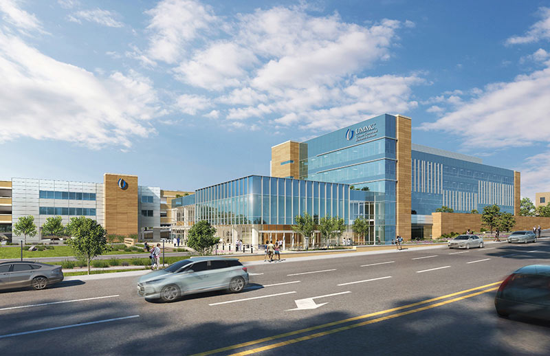 UMMC building exterior. Modern glass-and-brick medical building labeled “UMMC” stands beside a busy street with cars passing in front.