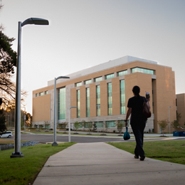 Person walking in front of the School of Medicine at UMMC