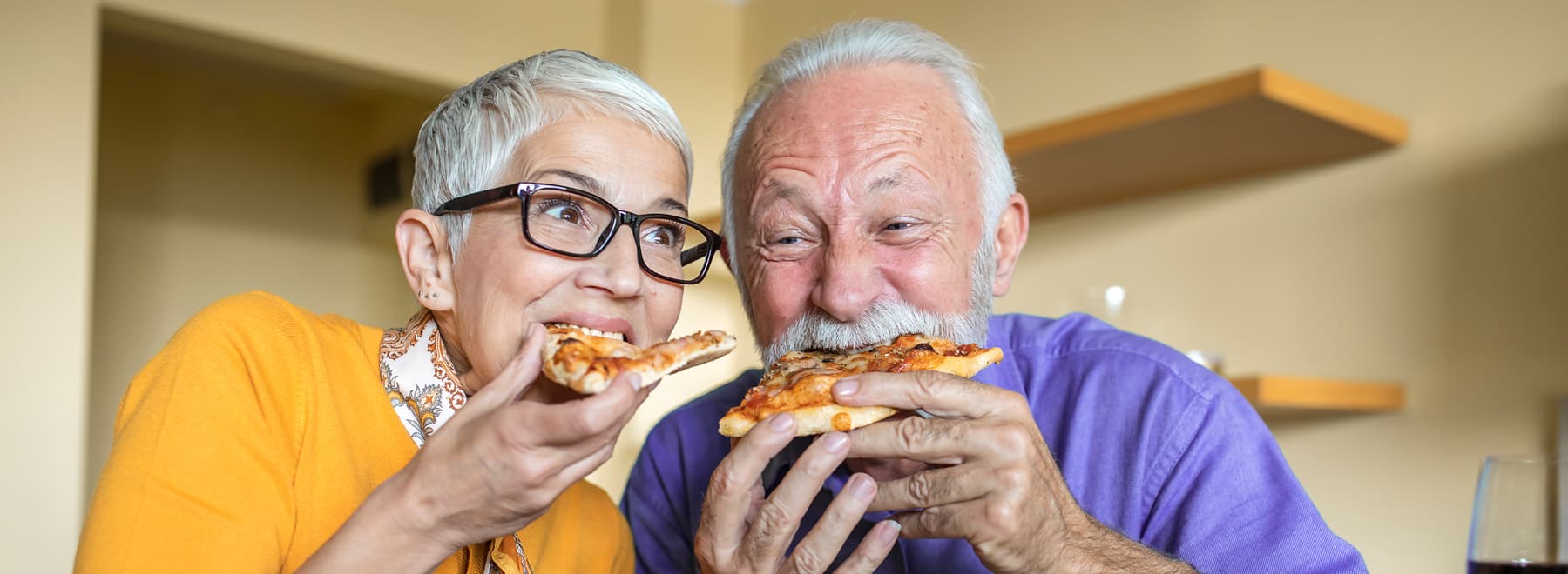 A couple enjoys slices of pizza