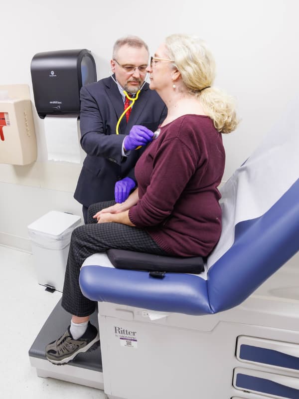 Dr. Pomianowski listens to a patient's heart.