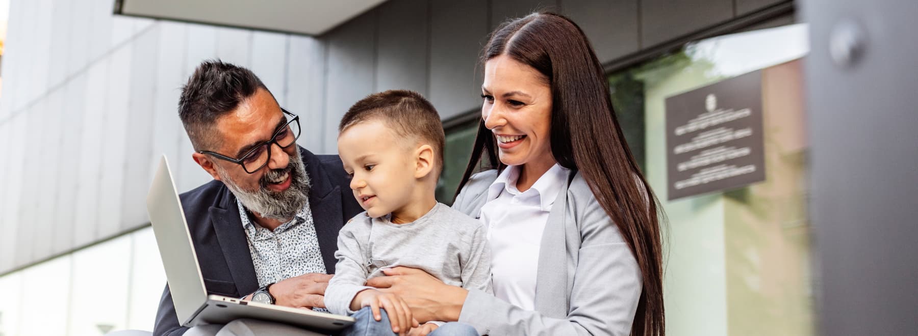 Family smiling while looking at computer.