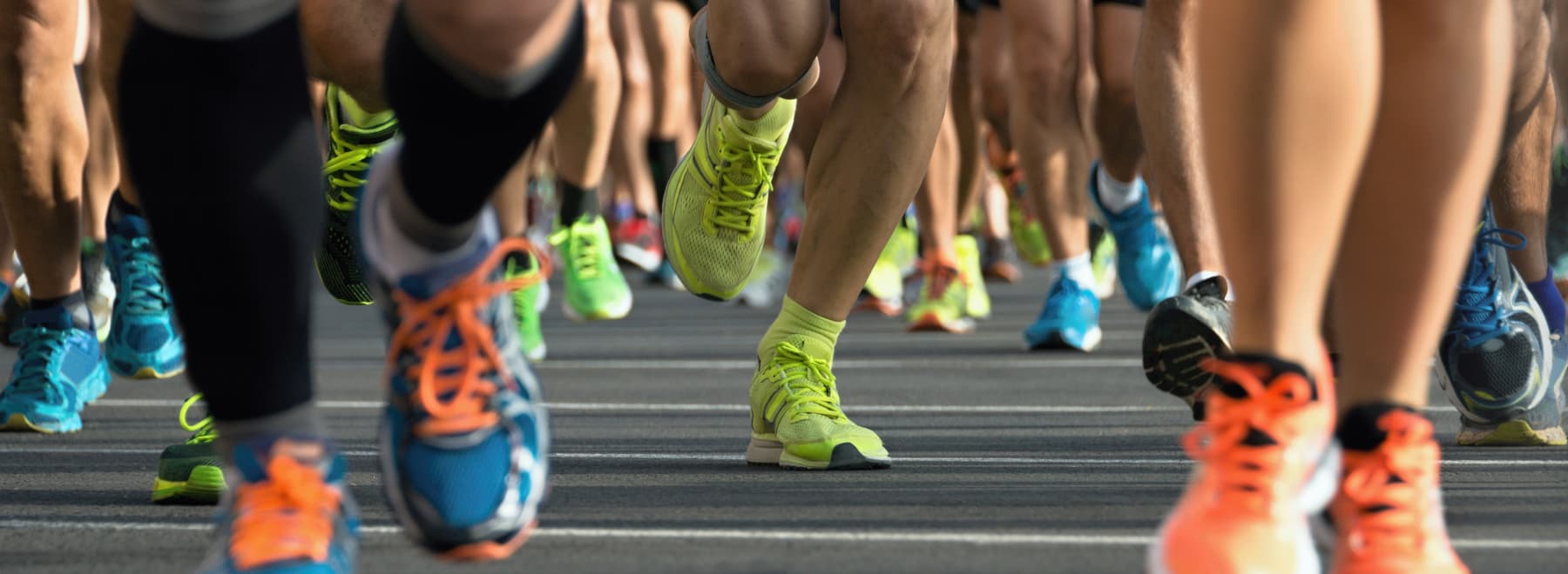 A number of people running in a race, showing only from about the knee down.