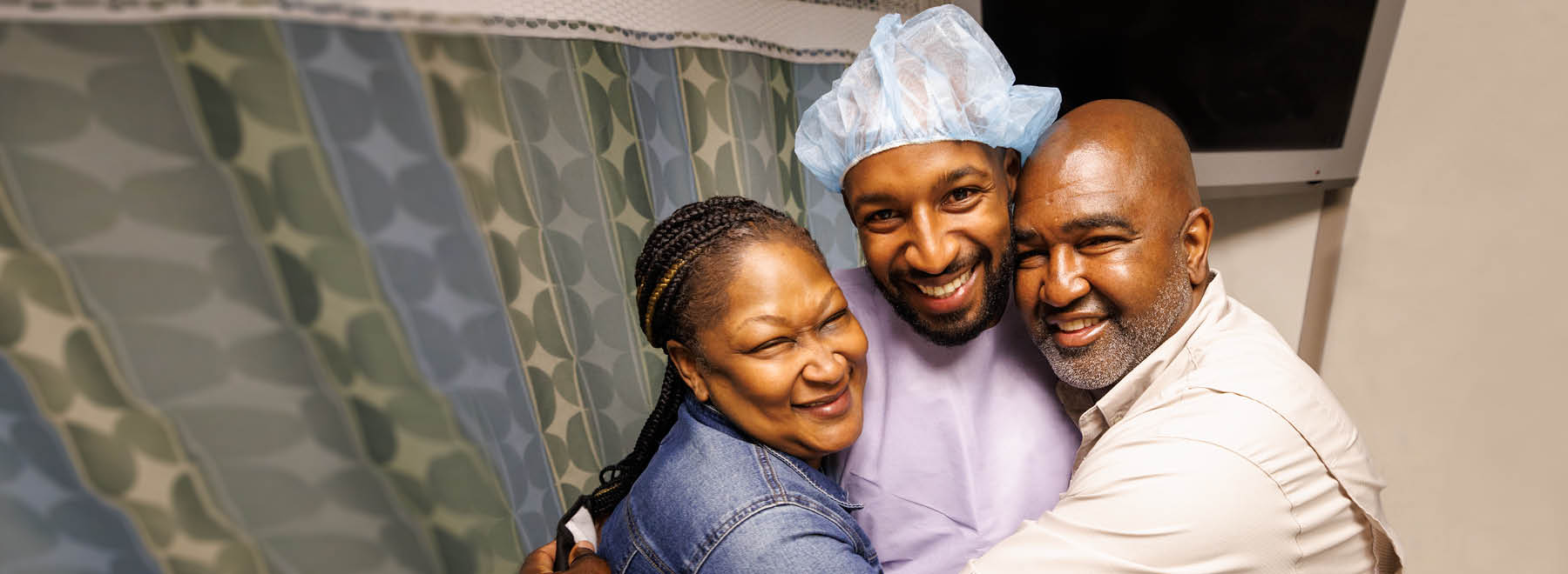 Family hugs patient while smiling.