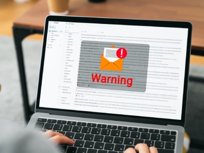 Laptop with warning pop-up on screen.