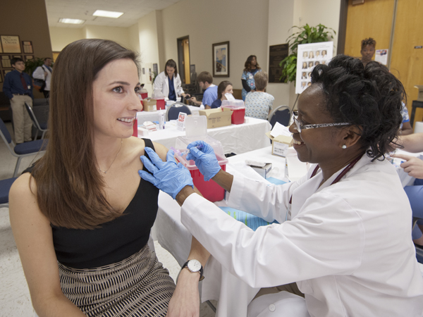University of Mississippi Medical Center first-year School of Medicine student Kate Garner prepares for the flu shot stick delivered by Olutade