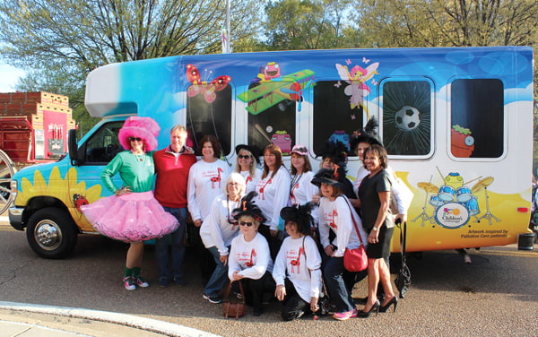 Proceeds from the 2014 Fondren's Zippity Doo Dah Weekend helped Friends purchase a new van for Batson’s palliative care patients. Jill Conner Browne, left and Braveheart screenwriter Randall Wallace, second from left, along with Queens Classymates members present the van to Ray, right.
