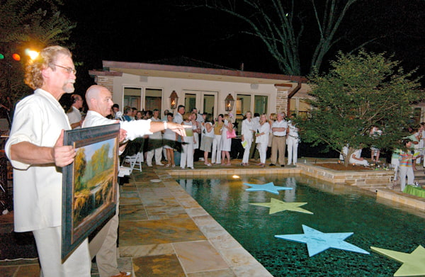 Volunteers encourage bidding on a piece of original artwork during a live auction at the 2005 Enchanted Evening.