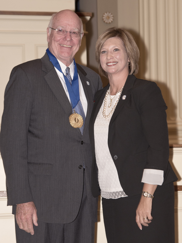 Dr. James Keeton, left, wears the medallion he has just received from his successor, Dr. LouAnn Woodward, vice chancellor for health affairs and dean of the School of Medicine.
