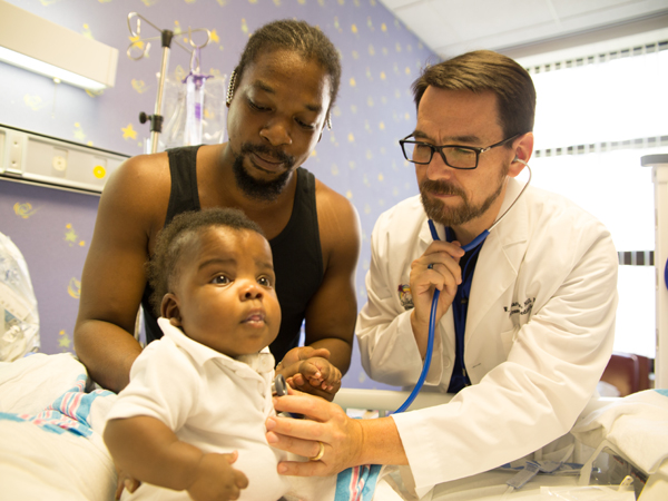 Boyte examines patient Queterrius Ellison, while his father Antonio holds him. Photo credit: The Schwartz Center for Compassionate Healthcare
