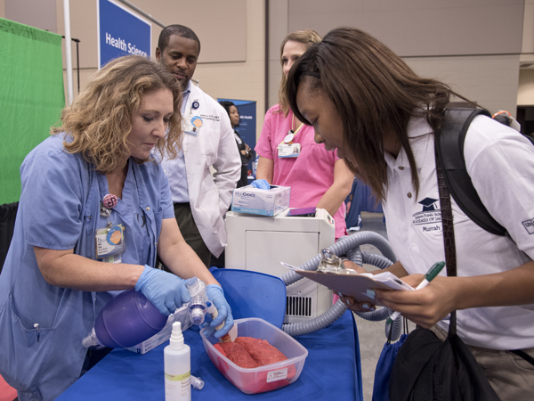 Respiratory Therapist Sheril Smith demonstrates artificial respiration with a pig's lung to Murrah student Azariah Johnson. Driscole DeVaul, director of Children's Respiratory Care, and respiratory therapist Michelle Bennett are in the background.