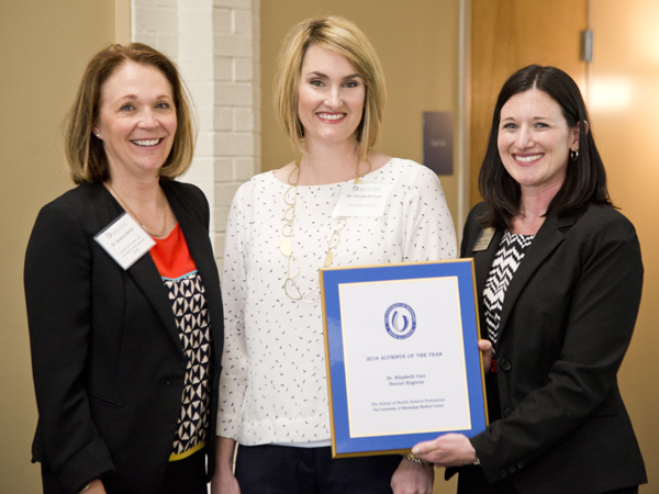 Carr, center, is recognized as Alumnus of the Year at the 2016 SHRP Alumni Day and Continuing Education event April 1 by dean of the school Dr. Jessica Bailey, left, and Megan James, Alumni Engagement Associate.