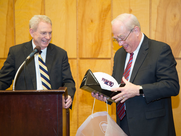 Jones watches as Thigpen, an avid Ole Miss fan, opens a gift from the University of Mississippi’s “top official,” a football signed by football coach Hugh Freeze.