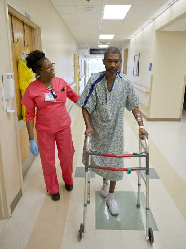 Jennifer Clay encourages patient Donald Dean of Shelby as he gains strength and gets back on his feet.