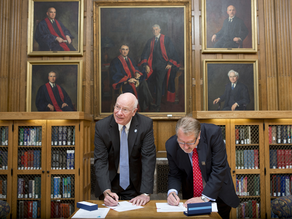 Dr. James E. Keeton, former UMMC vice chancellor for health affairs, left, and Dr. Greg Gores, Mayo Clinic executive dean for research, sign a formal agreement between their two medical centers on Sept. 30, 2014 in Rochester, Minnesota. The agreement allows UMMC and Mayo to partner on research, clinical trials and education.