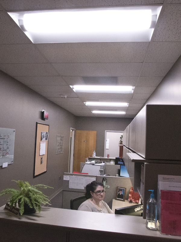 Donna Bridges, administrative assistant in the School of Medicine, is bathed in the brilliance of LED lighting at her desk in the Clinical Sciences Building.
