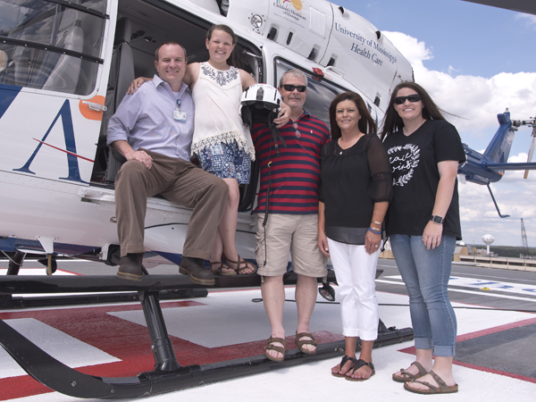 Abby is pictured with the critical care paramedic on her flight, Sam Marshall (left) and her family members: dad Ken, mom Melinda and sister Bailey.