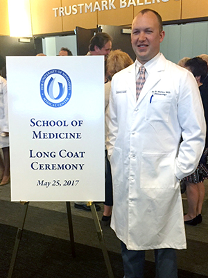 Harber poses for a picture after receiving his long white medical coat.