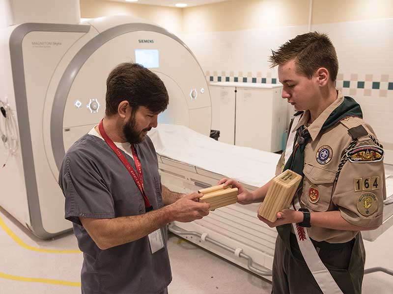 MRI technologist Troy Webb, a woodworker in his off hours, takes a look at the wooden model MRI machine made by Tickner.