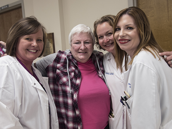 Celebrating the end of cancer treatment for Hinton (in pink) are oncology nurse Nikki Simmons; Dr. Barbara Craft, associate professor of medical oncology; and Dr. Natale Sheehan, assistant professor of medical oncology.
