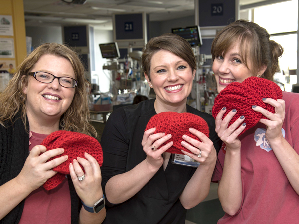 From left, executive assistant Selena Daniel of the Children's Heart Center, nurse practitioner Frannie Tynes and American Heart Association Go Red for Women director Christy Bridges show some of the many crocheted baby beanies donated for Little Hats, Big Hearts.