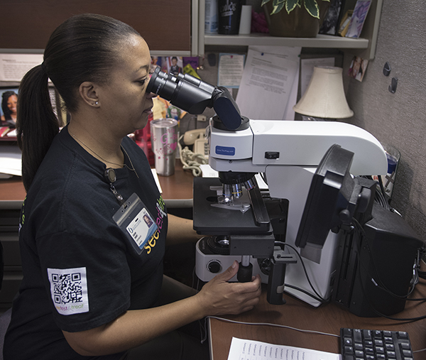 Sarah Short, cytotechnologist, reviews Pap test slides during the Jan. 28 See, Test & Treat event. Women screened were able to receive readings that same day.