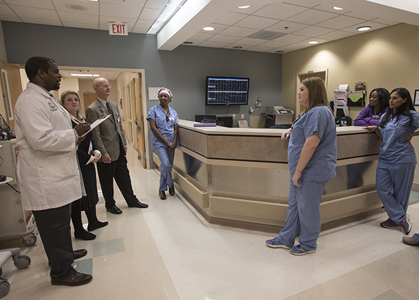 Driscoll Devaul, left, Molly Brasfield and Dr. Charles O'Mara speak with nurses and staff in labor and delivery at Wiser Hospital.