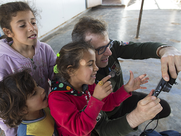 Bakdash shows children at the Al Zaatari refugee camp a camera.