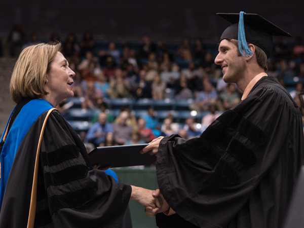 Dr. Jessica Bailey, dean of the School of Health Related Professions, gives a diploma to James Kimbrough, who earned the doctor of physical therapy degree and was honored with the Dr. Virginia Stansel Tolbert award as the student with the highest academic average in the School of Health Related Professions.