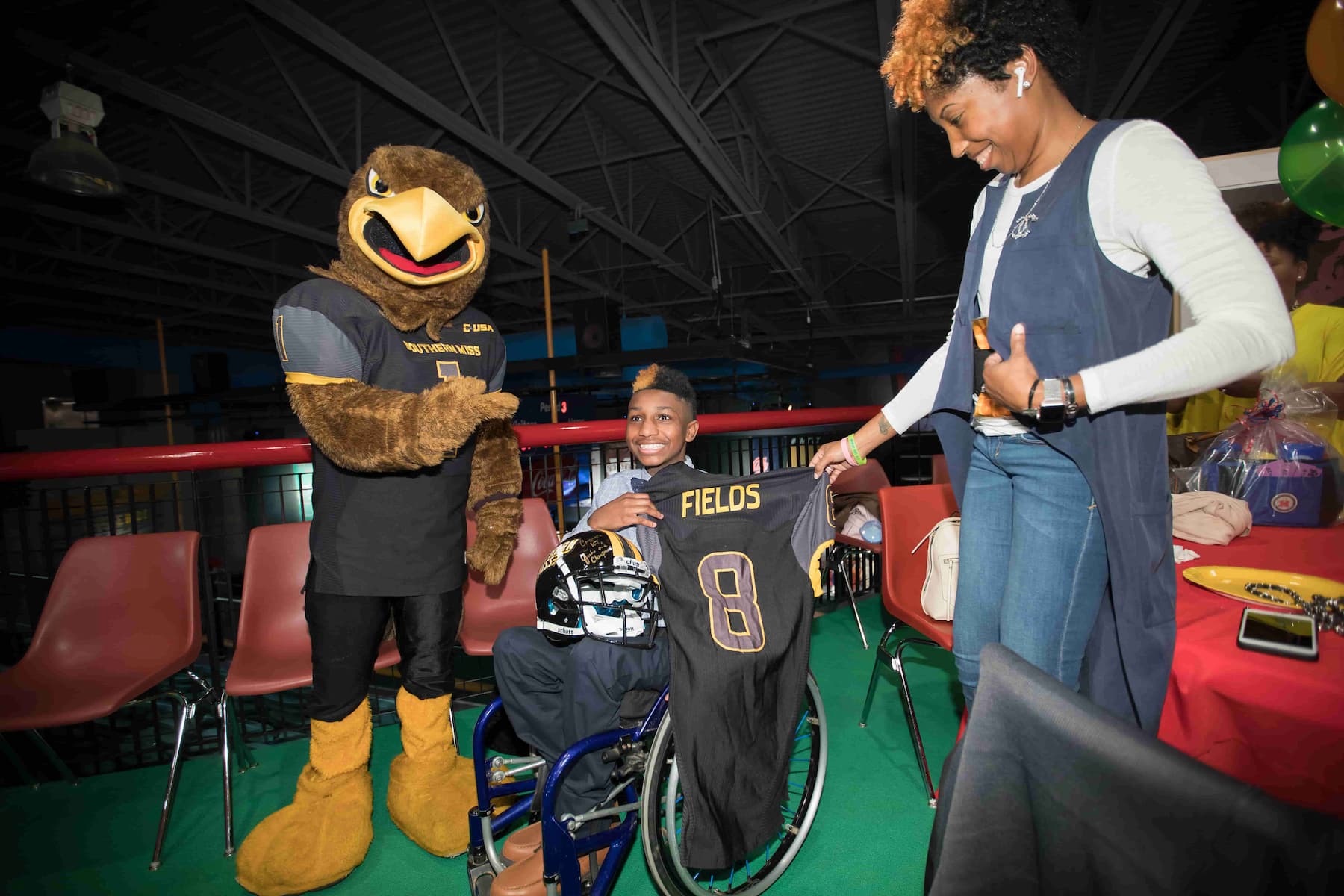 2018 Children's Miracle Network Champion KJ Fields and mom DeeWanda Fields, a University of Southern Mississippi alumna, smile with Southern Miss mascot Seymour.