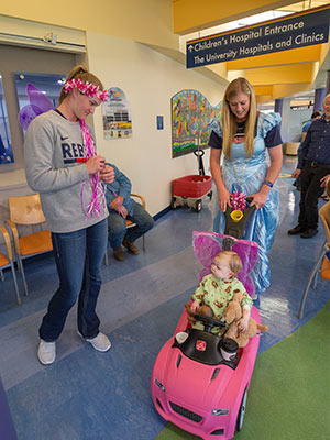 Ole Miss softball players Brittany Finney, left, and Alex Schneider give Batson Children's Hospital patient Emma Grace Simpson of Hattiesburg a ride in her pink convertible during a hospital visit Tuesday.