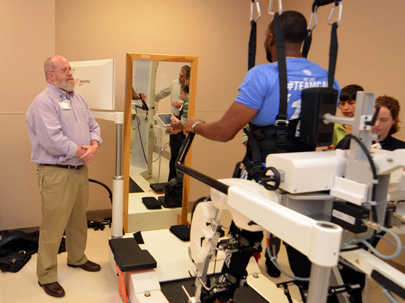 Dr. Keith Tansey, UMMC professor of neurosurgery; and Methodist Rehab employees Tremaine Nathan, assistive technology specialist; physical therapist Patricia Oyarce; and research physical therapist Annie Rieher train on a gait rehabilitation system in Methodist Rehabilitation Center’s neurorobotics laboratory.