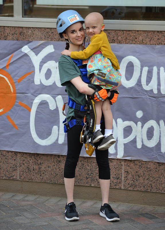 Natalie Joiner, one of the "Edgers" rappelling at Over The Edge, holds her inspiration, Batson Children's Hospital patient Iva Beth Lindsey.
